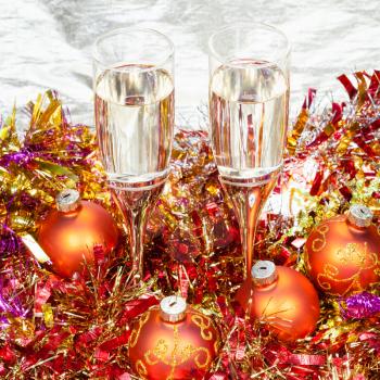 Christmas still life - above view of two glasses of champagne with orange Xmas decorations on gold background