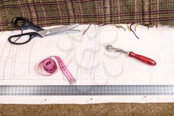 dressmaking still life - top view of cutting table with cloth, pattern, tailoring tools