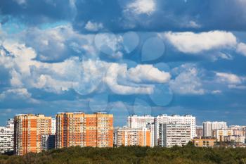 heavy low blue clouds over modern urban houses in summer