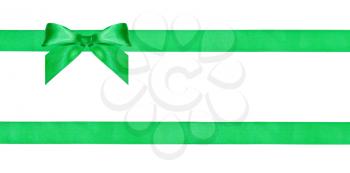 one green bow knot on two parallel silk ribbons isolated on white background