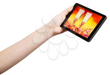 hand holds tablet-pc with Xmas still life on screen isolated on white background