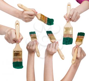 set of painter hands with flat paint brushes with green painted tips isolated on white background
