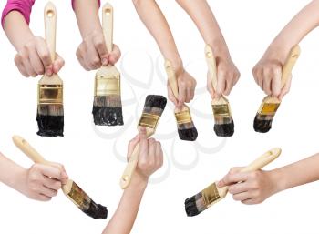 set of painter hands with flat paint brushes with black painted tips isolated on white background