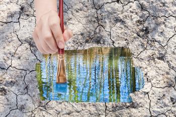 nature concept - seasons and weather changing: hand with paintbrush paints water puddle on dried earth
