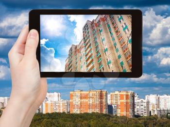 travel concept - tourist photographs picture of urban houses on tablet pc
