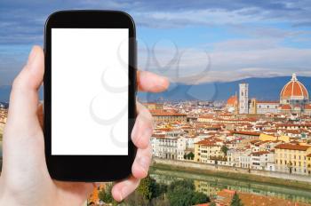 travel concept - hand holds smartphone with cut out screen and Florence skyline on background