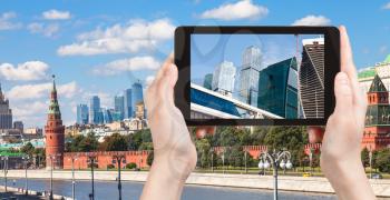 travel concept - tourist photographs picture of Moscow City on tablet pc