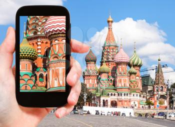 travel concept - tourist photographs picture of Saint Basil Cathedral in Moscow on smartphone
