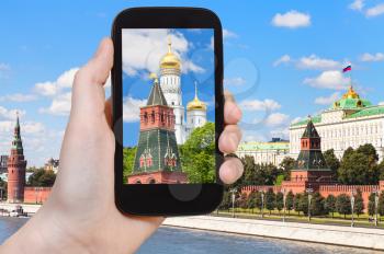 travel concept - tourist photographs picture of cathedral in Moscow Kremlin on smartphone