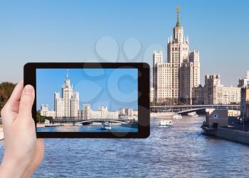 travel concept - tourist photographs picture high-rise apartment building on Kotelnicheskaya Embankment in Moscow on tablet pc