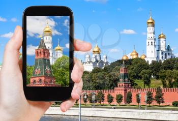 travel concept - tourist photographs picture of Ivan The Great bell tower in Moscow Kremlin on smartphone