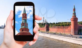 travel concept - tourist photographs picture of Beklemishevskaya Tower (Moskvoretskaya Tower) of Moscow Kremlin on smartphone