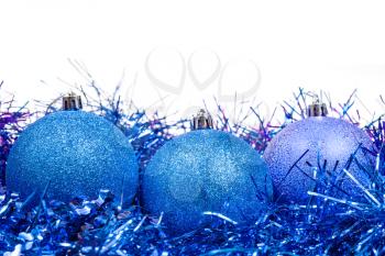few blue Christmas baubles and tinsel isolated on white background