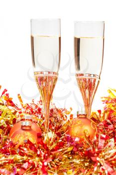 two glasses of sparkling wine at yellow and golden Christmas decorations isolated on white background