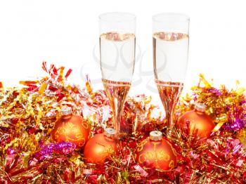 two glasses of champagne at yellow and orange Xmas decorations isolated on white background