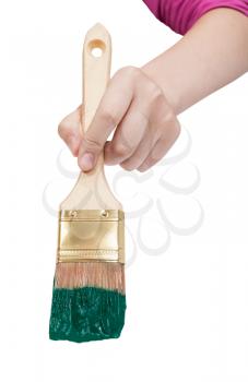 direct view of painter hand with flat paintbrush painting in green paint isolated on white background
