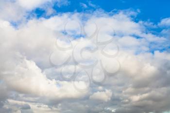 natural background - low dense gray and white autumn clouds in blue sky