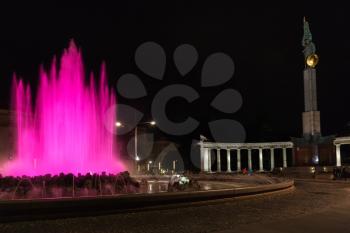 travel to Vienna city - pink illuminated Hochstrahlbrunnen fountain and Soviet War Memorial on Schwarzenbergplatz square, Vienna,Austria