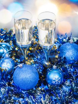 Christmas still life - above view of two glasses of champagne in blue Xmas decorations with blue blurred bokeh background