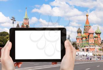 travel concept - hand holds tablet pc with cut out screen and Moscow street and cathedral on background