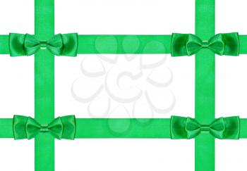 four double green bow knots on four satin ribbons isolated on white background