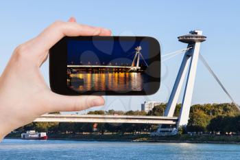 travel concept - tourist snapshot of SNP Bridge (UFO bridge, Novy Most, New Bridge) over Danube river in Bratislava on smartphone