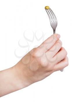 female hand holds fork with impaled green pea isolated on white background