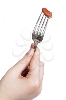 one brown bean impaled on fork in female hand isolated on white background