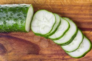 sliced fresh cucumber on wooden cutting board