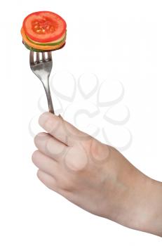 fresh sliced vegetables impaled on fork in female hand isolated on white background