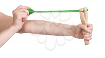 hands pull green rubber band of simple wooden slingshot isolated on white background