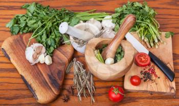 cooking seasonings - mortars and fresh herbs on wooden table