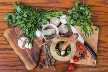 cooking seasonings - above view of mortars and fresh herbs on wooden table