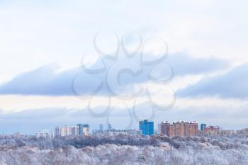 blue clouds over urban park and town in winter season