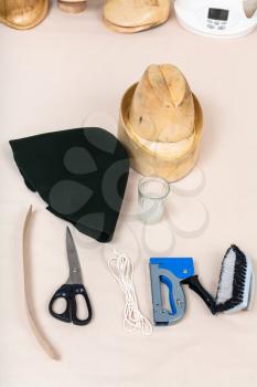 workshop for alpine felt hat making - wool felt hood, wooden hat-block and tools for hatmaking