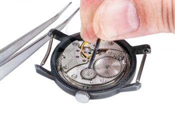 adjusting old mechanic wristwatch - watchmaker repairs old watch isolated on white background