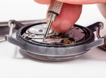 adjusting old mechanic wristwatch - watch repairer repairs old watch close up