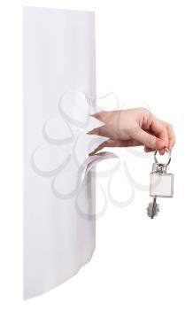 side view of hand holds the keychain through a hole in a sheet of paper isolated on white background