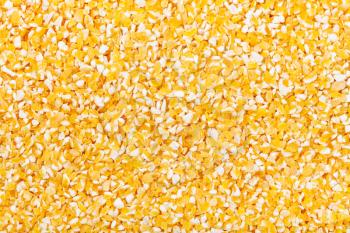 food background - raw yellow ground corn groats