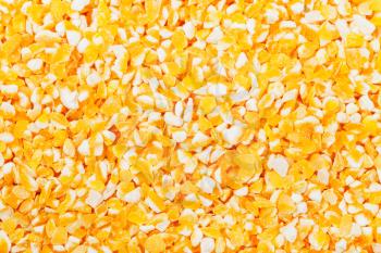 food background - raw yellow crushed corn groats