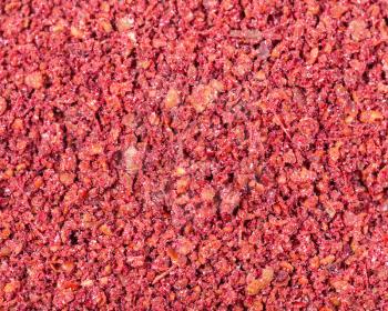 food background - ground sumac ( sumach, rhus) spice close up