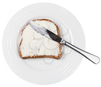 above view of table knife on grain bread and Cheese spread sandwich on white plate isolated on white background