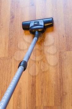 above view vacuuming of parquet floor by vacuum cleaner at home