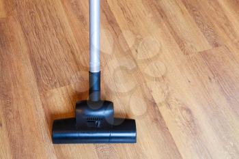 direct view of vacuuming of laminate floor by vacuum cleaner at home