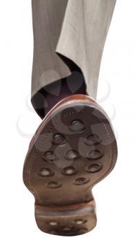 front view of male right leg in brown shoe takes a step isolated on white background