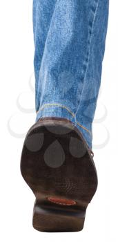 direct view of male left leg in jeans and brown shoe takes a step isolated on white background