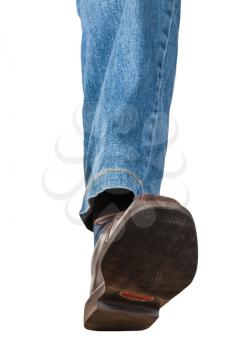front view of male left leg in jeans and brown shoe takes a step isolated on white background