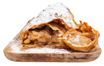piece of typical austrian apple strudel on wooden board isolated on white background