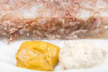 mustard and horseradish - typical seasonings for aspic aspic on white plate close up