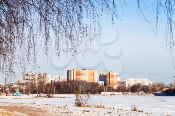 frozen lake and urban houses in cold winter day